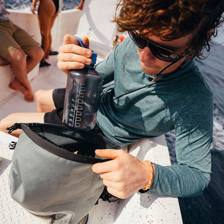 Putting a bottle in the Rolltop Sling